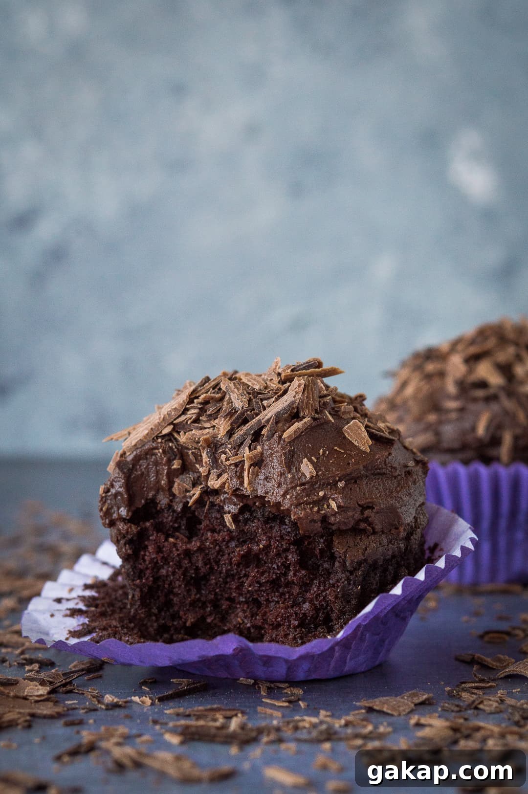 Chocolate cupcakes for two - a small batch of just two delicious vegan chocolate cupcakes that are incredibly quick and easy to whip up and so tasty! Perfect for Valentines Day. #vegan #veganbaking #vegancupcakes #smallbatch A shot of a chocolate cupcake with a bite taken out of it.