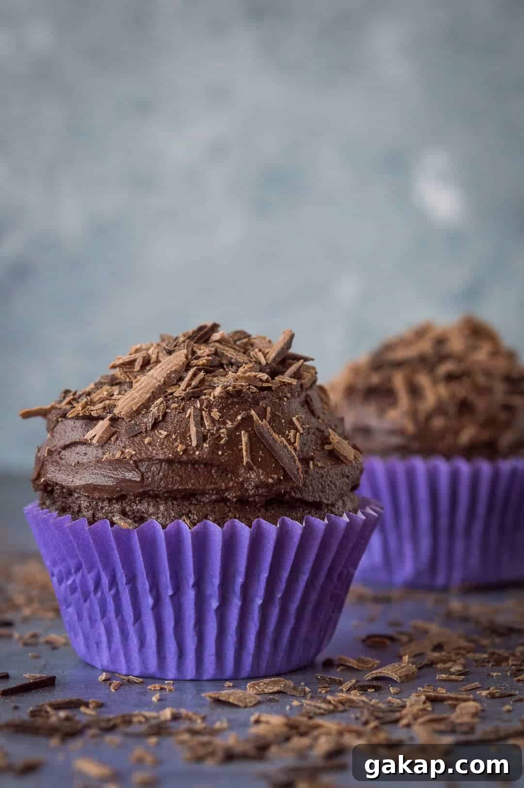 Chocolate cupcakes for two - a small batch of just two delicious vegan chocolate cupcakes that are incredibly quick and easy to whip up and so tasty! Perfect for Valentines Day. #vegan #veganbaking #vegancupcakes #smallbatch Two vegan chocolate cupcakes in purple cake cases.