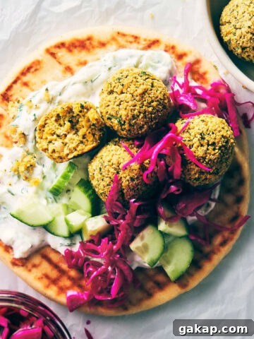 Close up of falafel on a pita with pickled cabbage and tzatziki