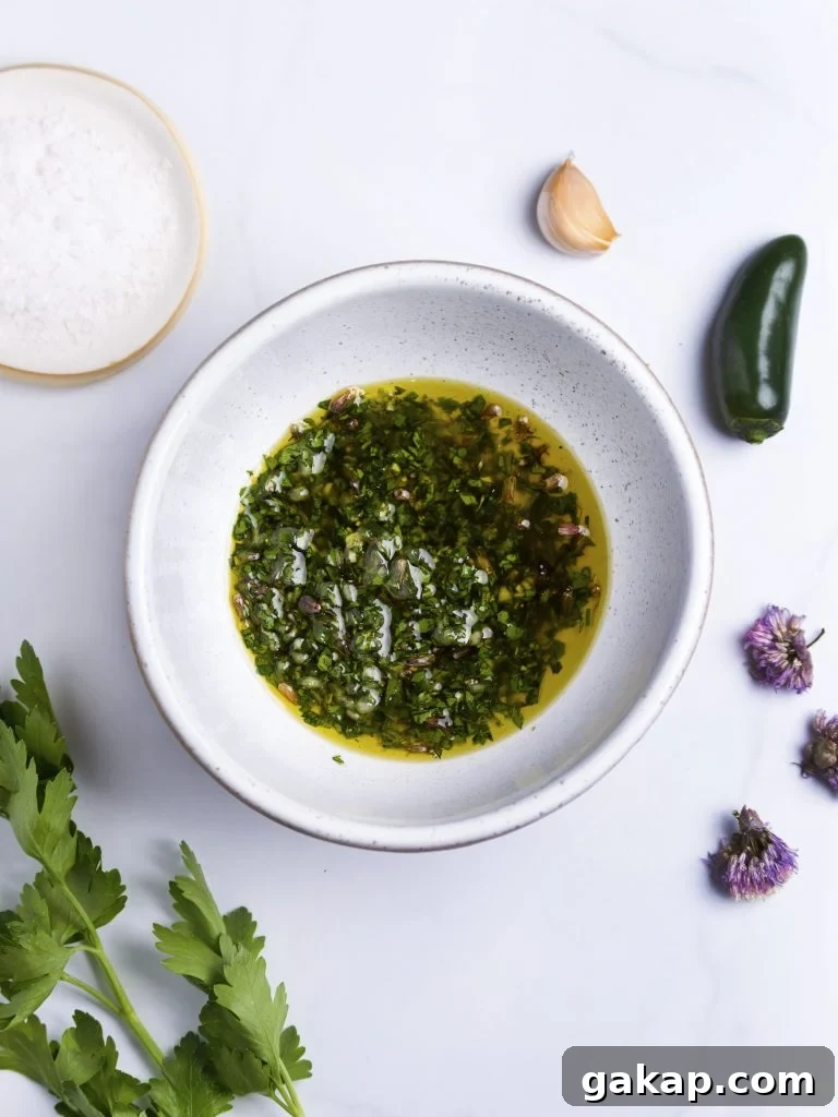 herb oil in a white bowl made with fresh herbs, pepper and garlic