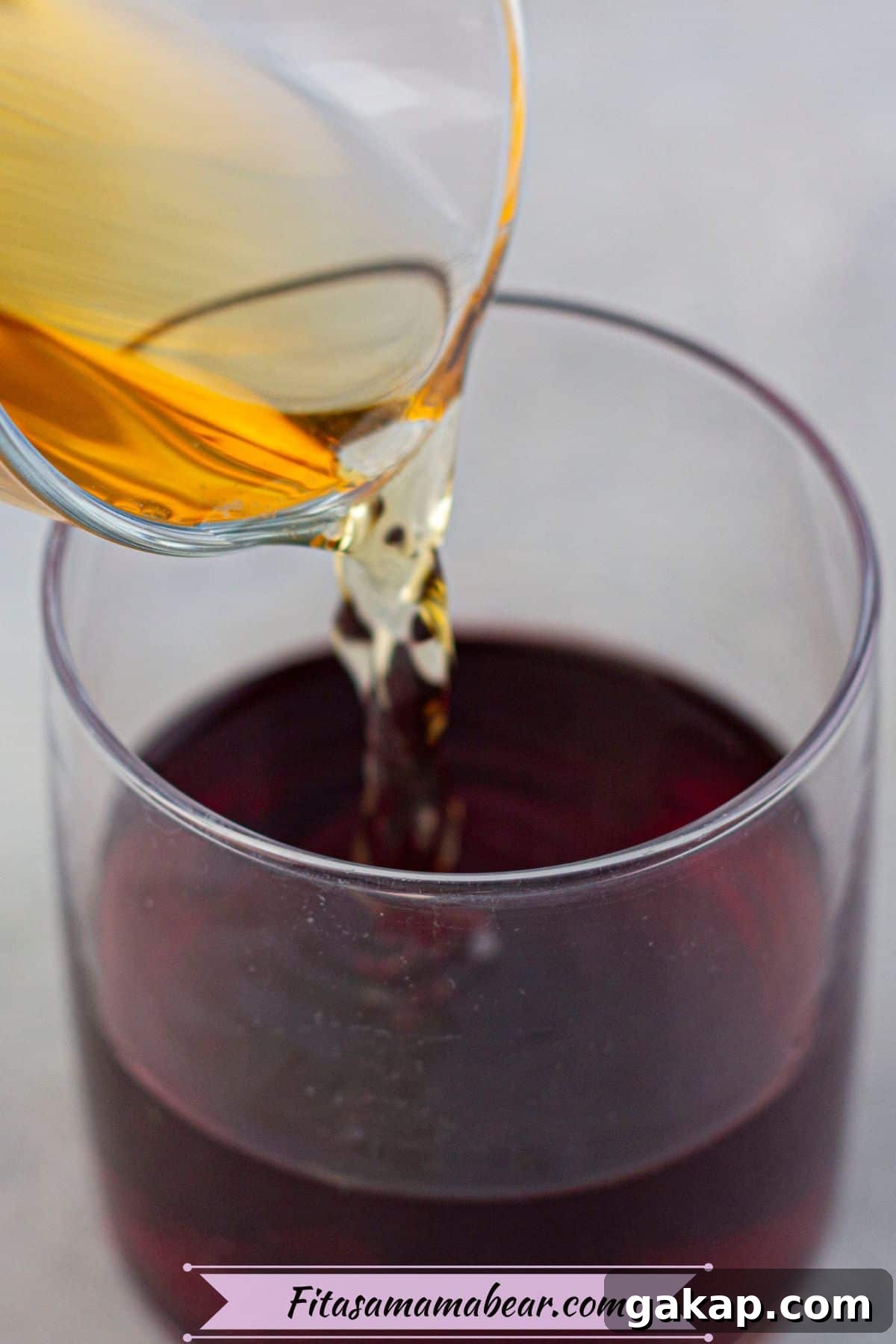 Sparkling Kombucha Mocktail Recipe for Refreshing Summer Sips 4 Kombucha being poured into a glass with pomegranate juice in it.