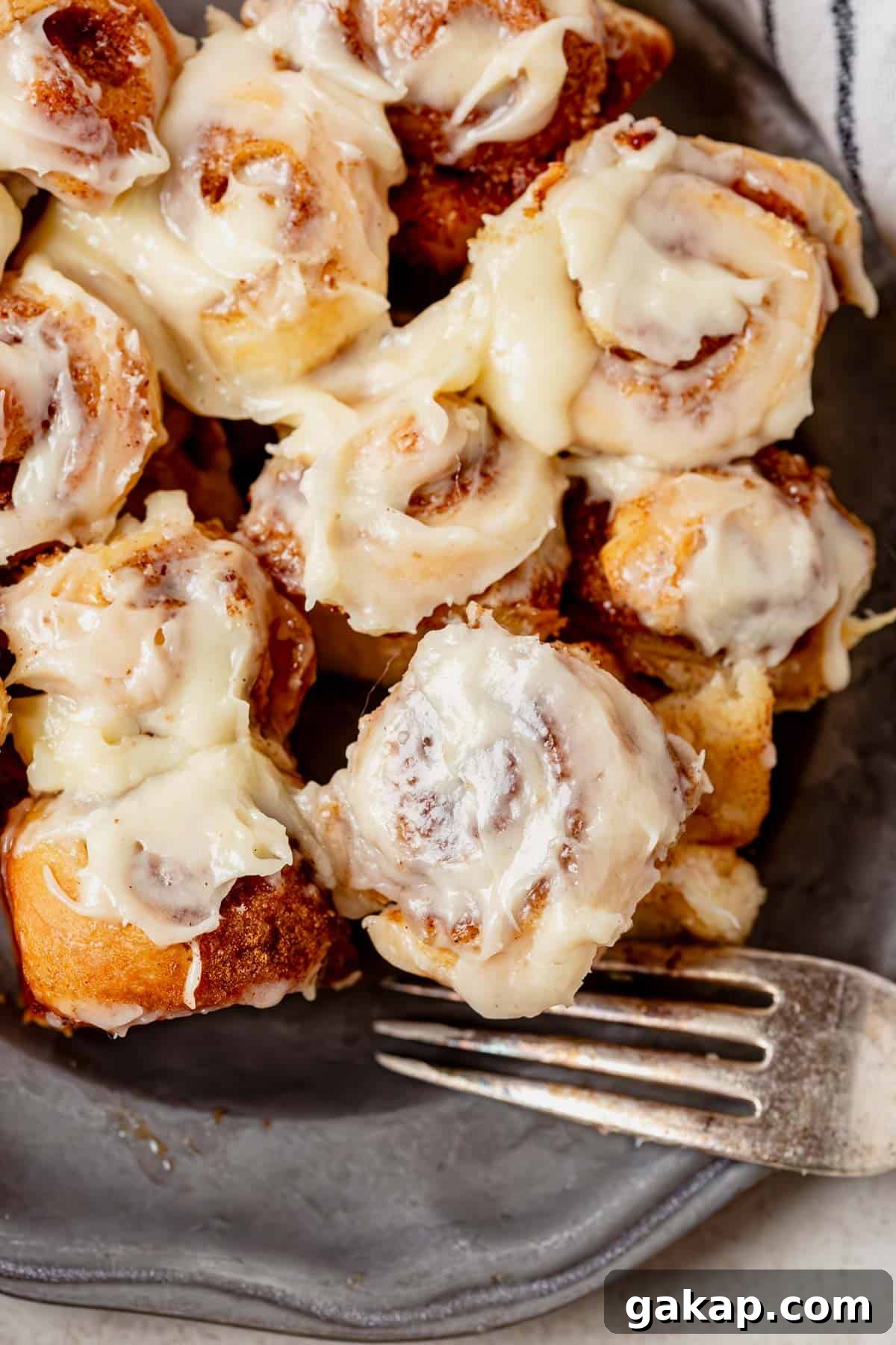 a plate of mini cinnamon rolls with a fork.
