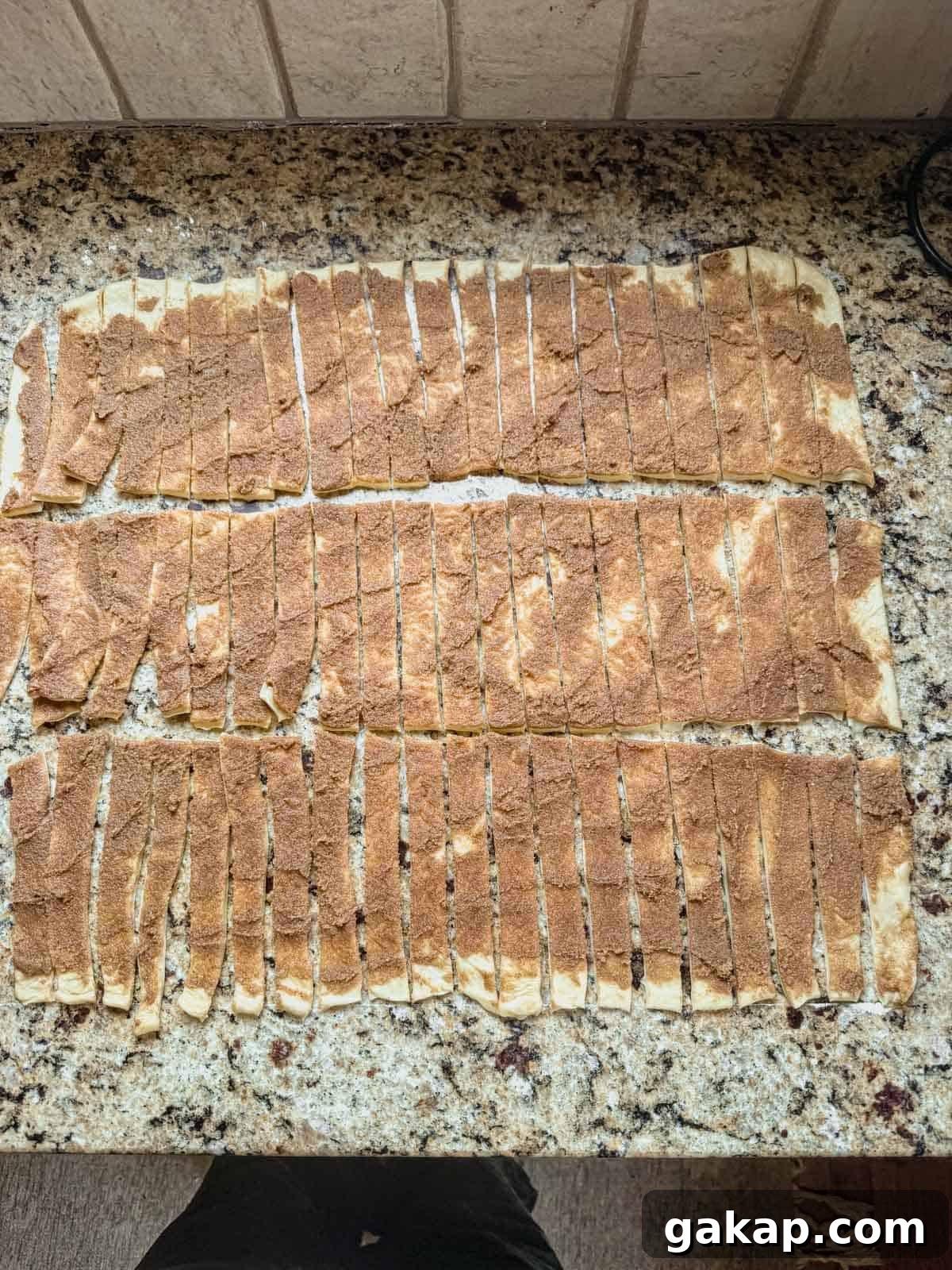 cinnamon roll dough cut into 60 small strips before rolling into mini cinnamon rolls.