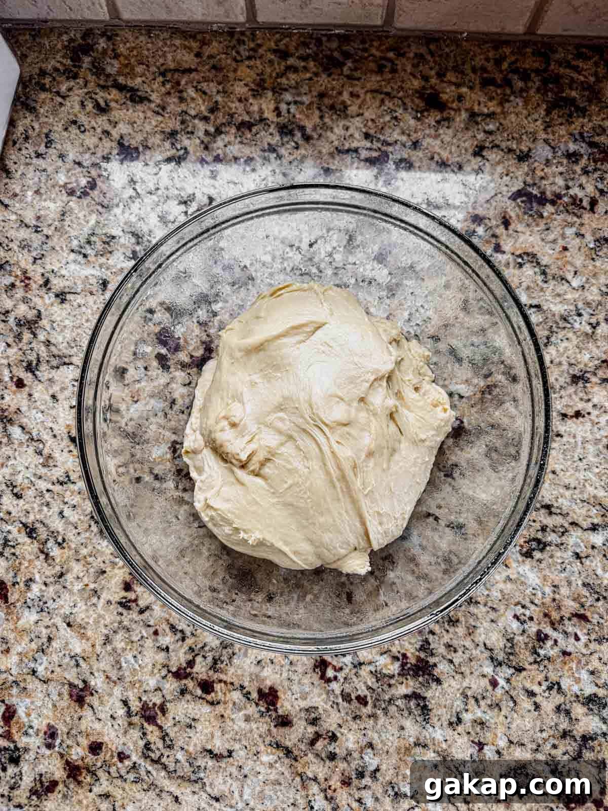 cinnamon roll enriched dough in a greased glass bowl before rising.