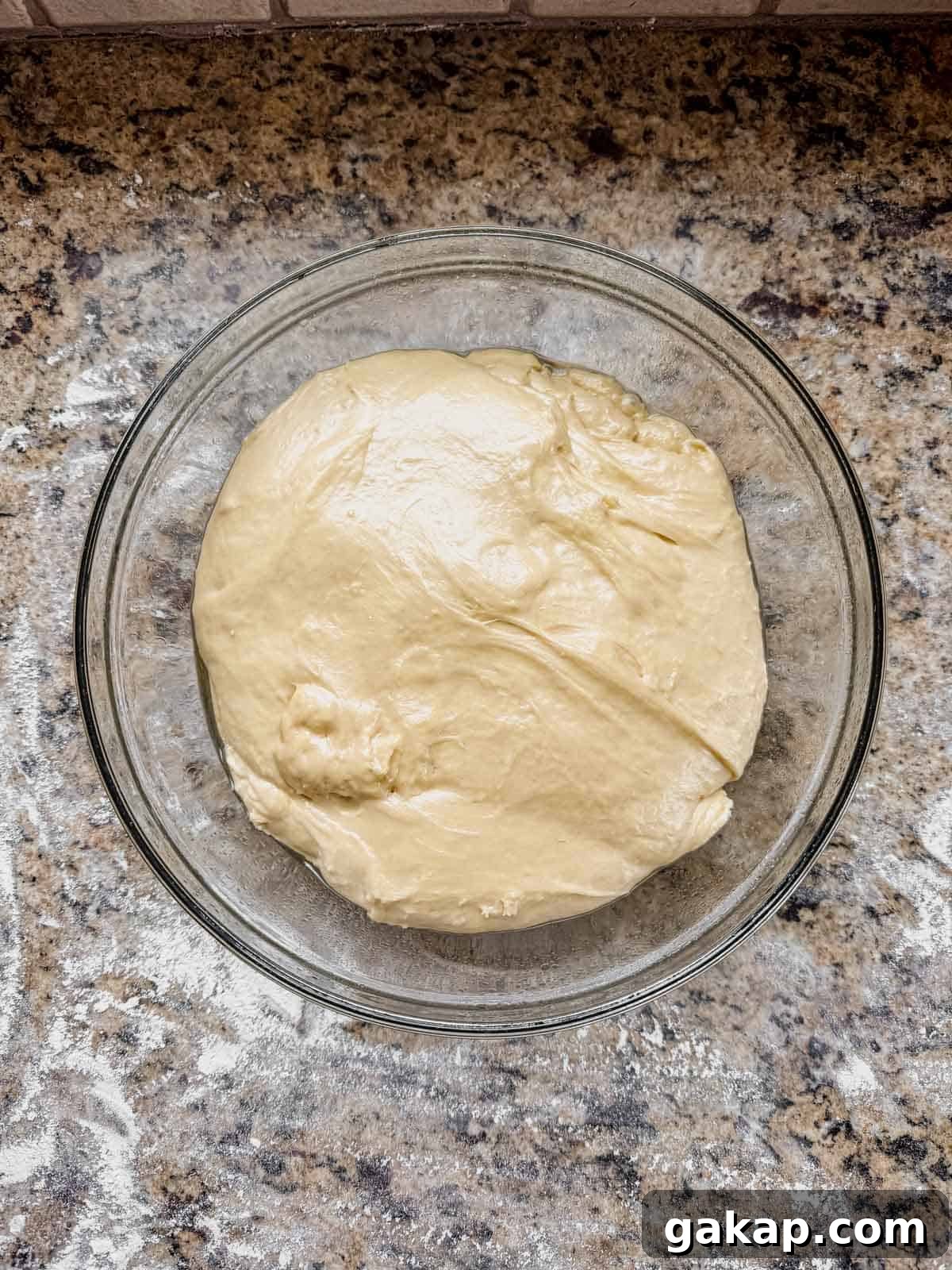 cinnamon roll enriched dough in a greased glass bowl after rising.