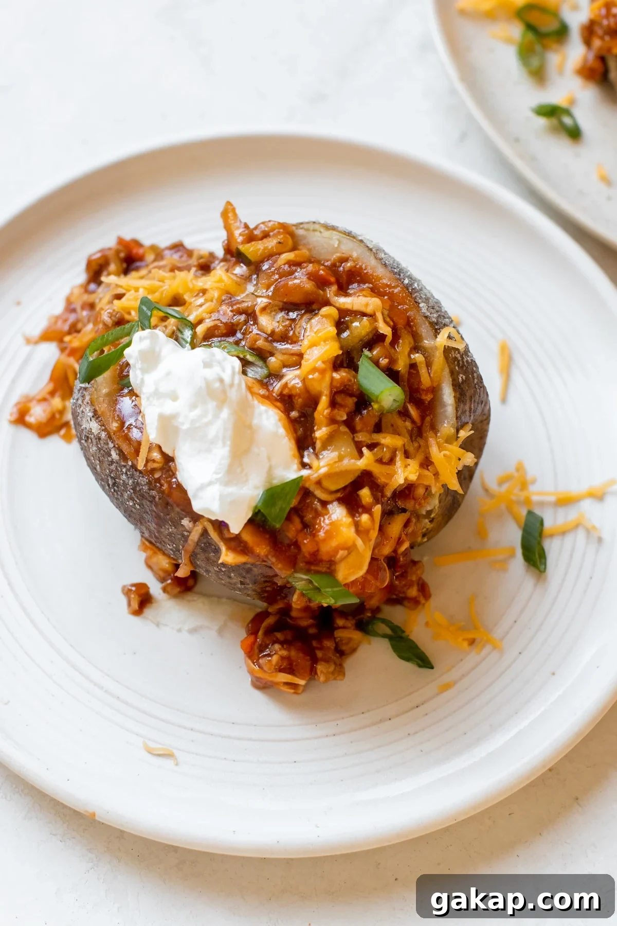 Sloppy Joe Stuffed Baked Potato Recipe: Hearty Weeknight Meal 6 a baked potato stuffed with a ground turkey meat sauce and topped with cheese, green onions and sour cream