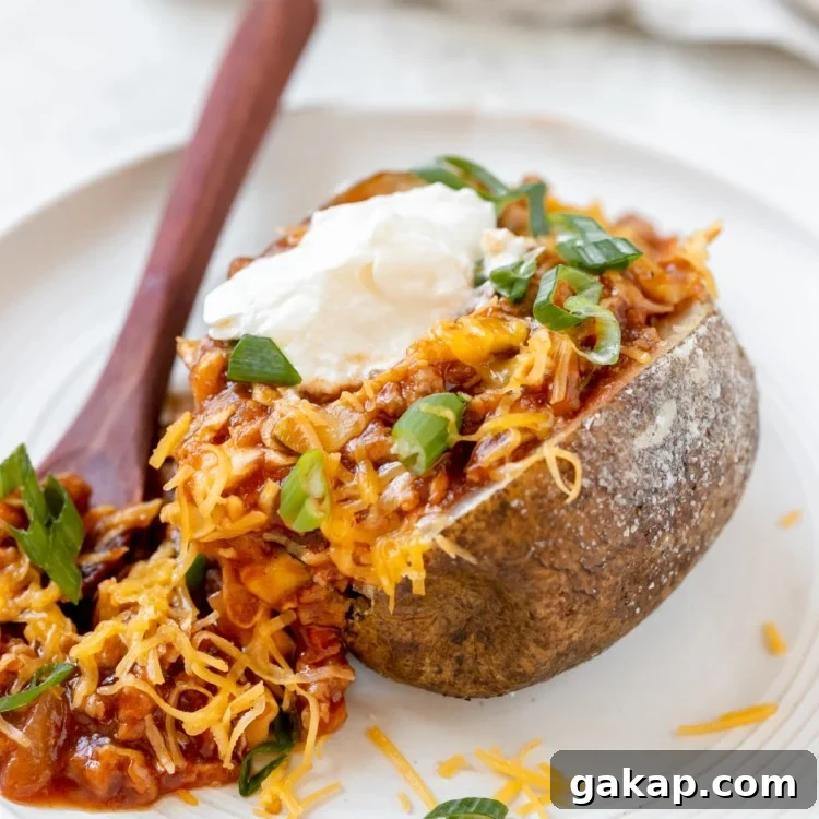 Sloppy Joe Stuffed Baked Potato Recipe: Hearty Weeknight Meal 7 a baked potato filled with sloppy joe meat sauce and garnished with green onions, cheese and sour cream