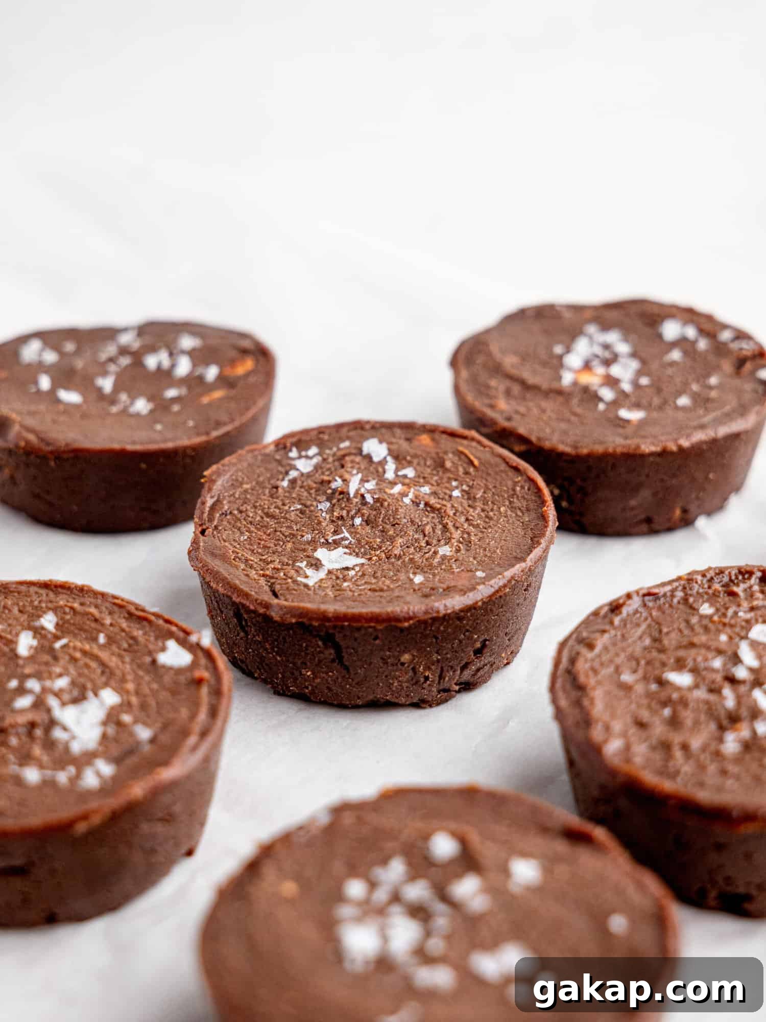 Chocolate fudge cups on a sheet of parchment paper.