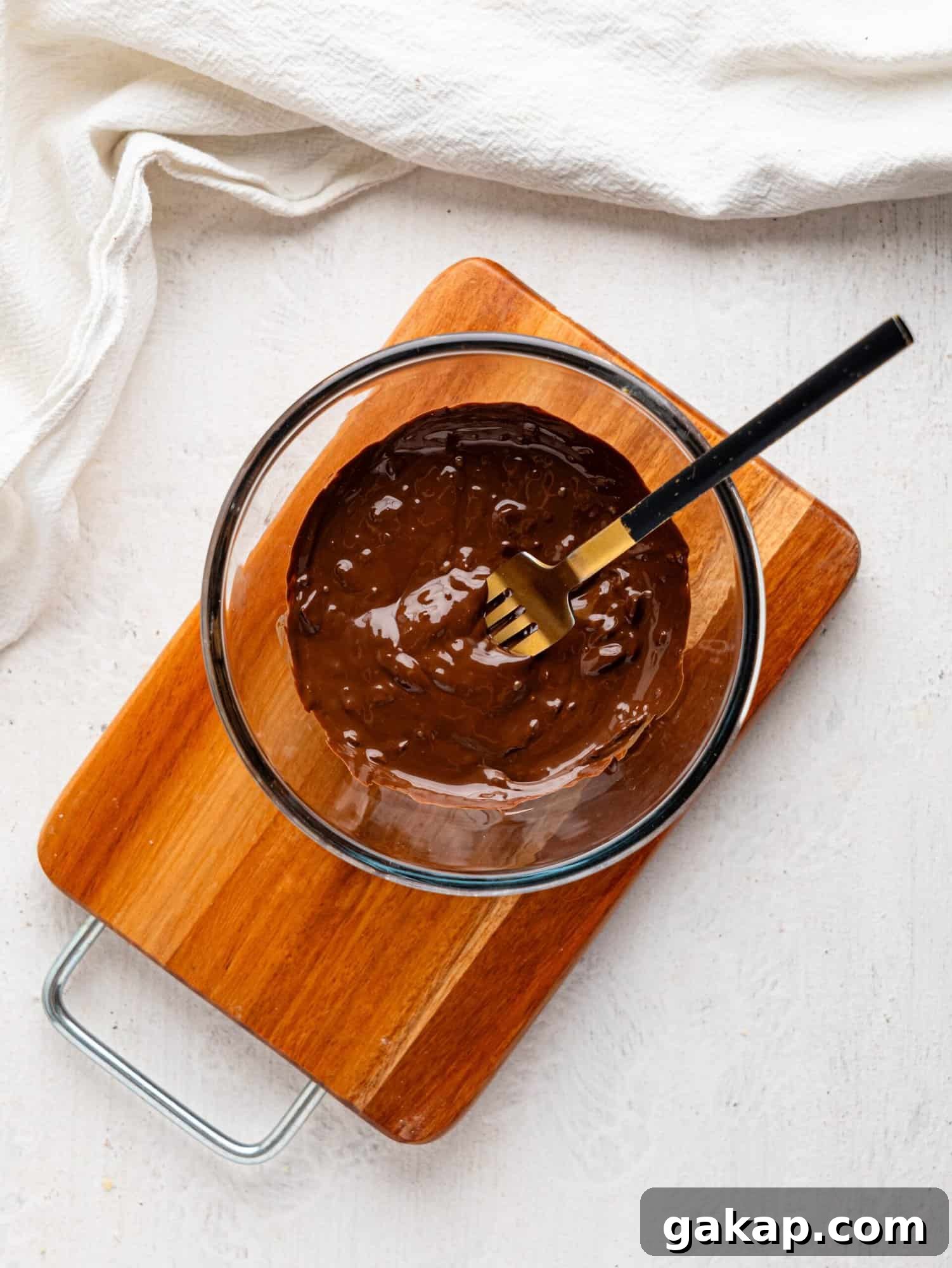 Melted dark chocolate in a glass bowl.