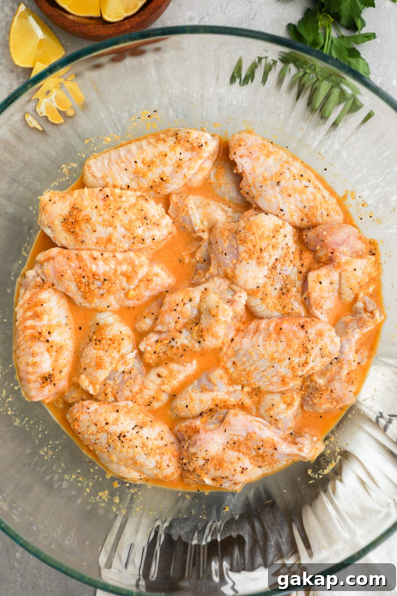 Crispy Lemon Garlic Chicken Wings Recipe 5 A large clear bowl filled with chicken wings marinating in a lemon garlic mixture