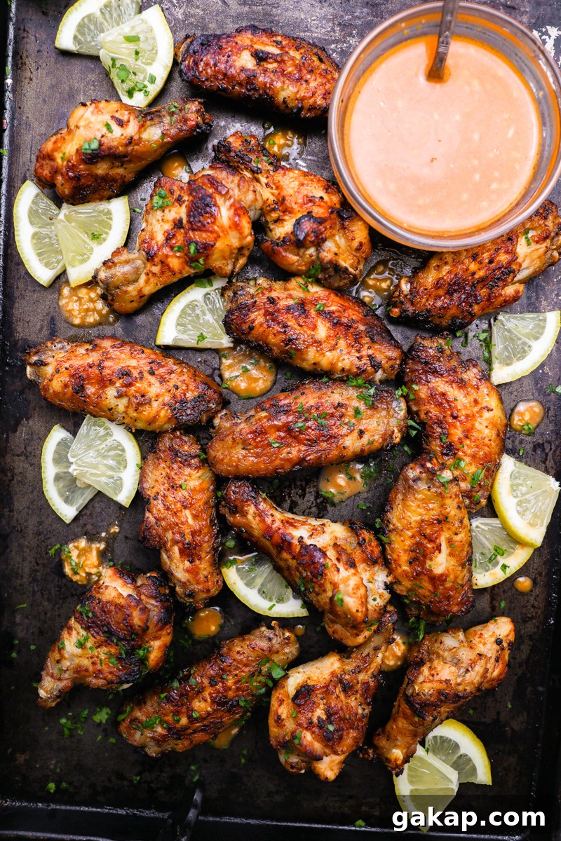 Crispy Lemon Garlic Chicken Wings Recipe 8 Lemon garlic chicken wings sitting on a serving tray with fresh lemon wedges garnished with chopped parsley