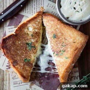 Overhead of a brioche grilled cheese cut in half on a wood surface.