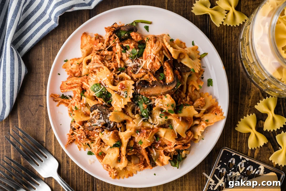 Creamy Slow Cooker Chicken and Bacon Pasta Recipe 7 overhead shot of serving of slow cooker chicken bacon pasta on a white plate.