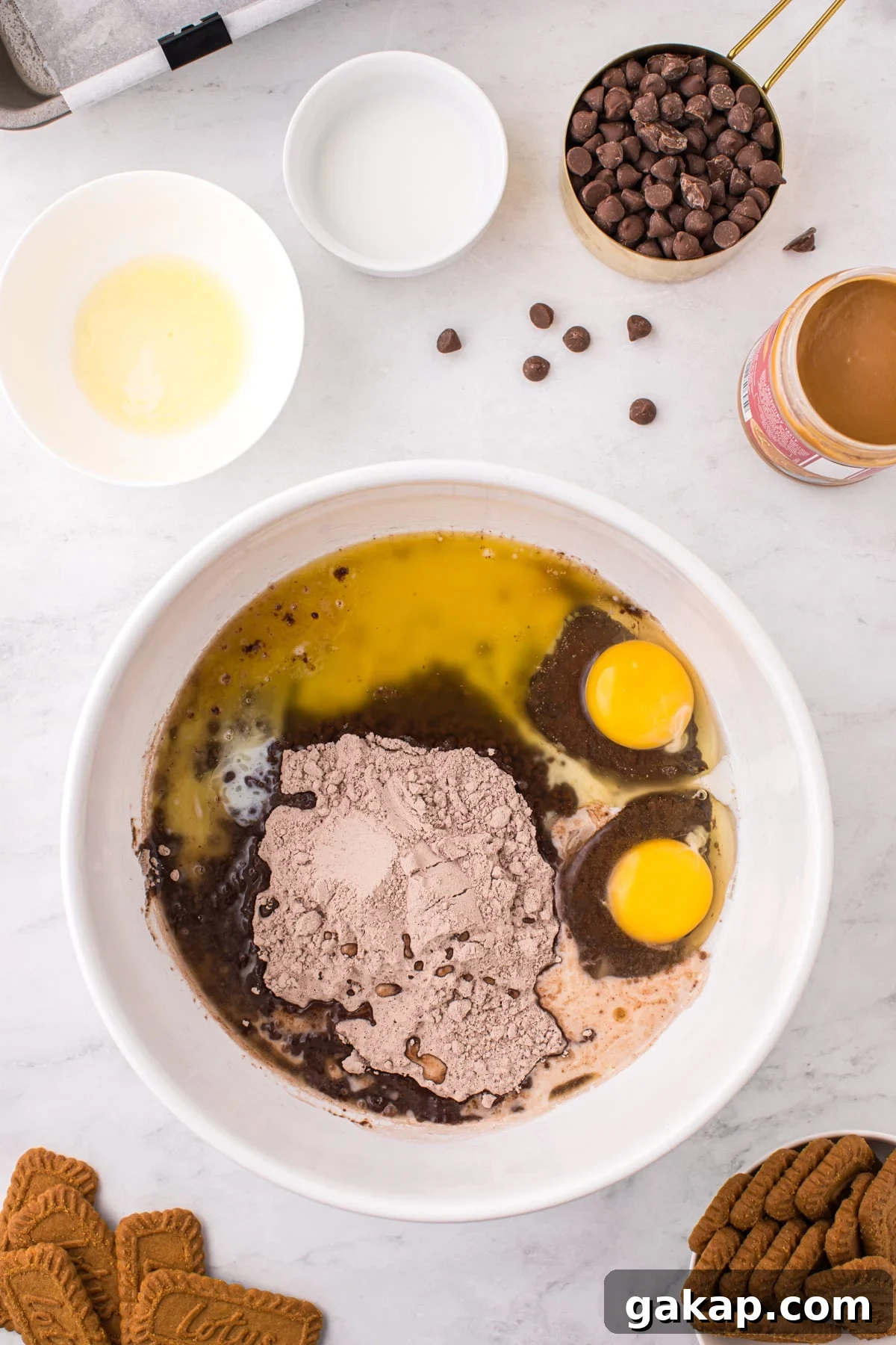 A bowl filed with brownie mix, eggs, milk, and melted butter.