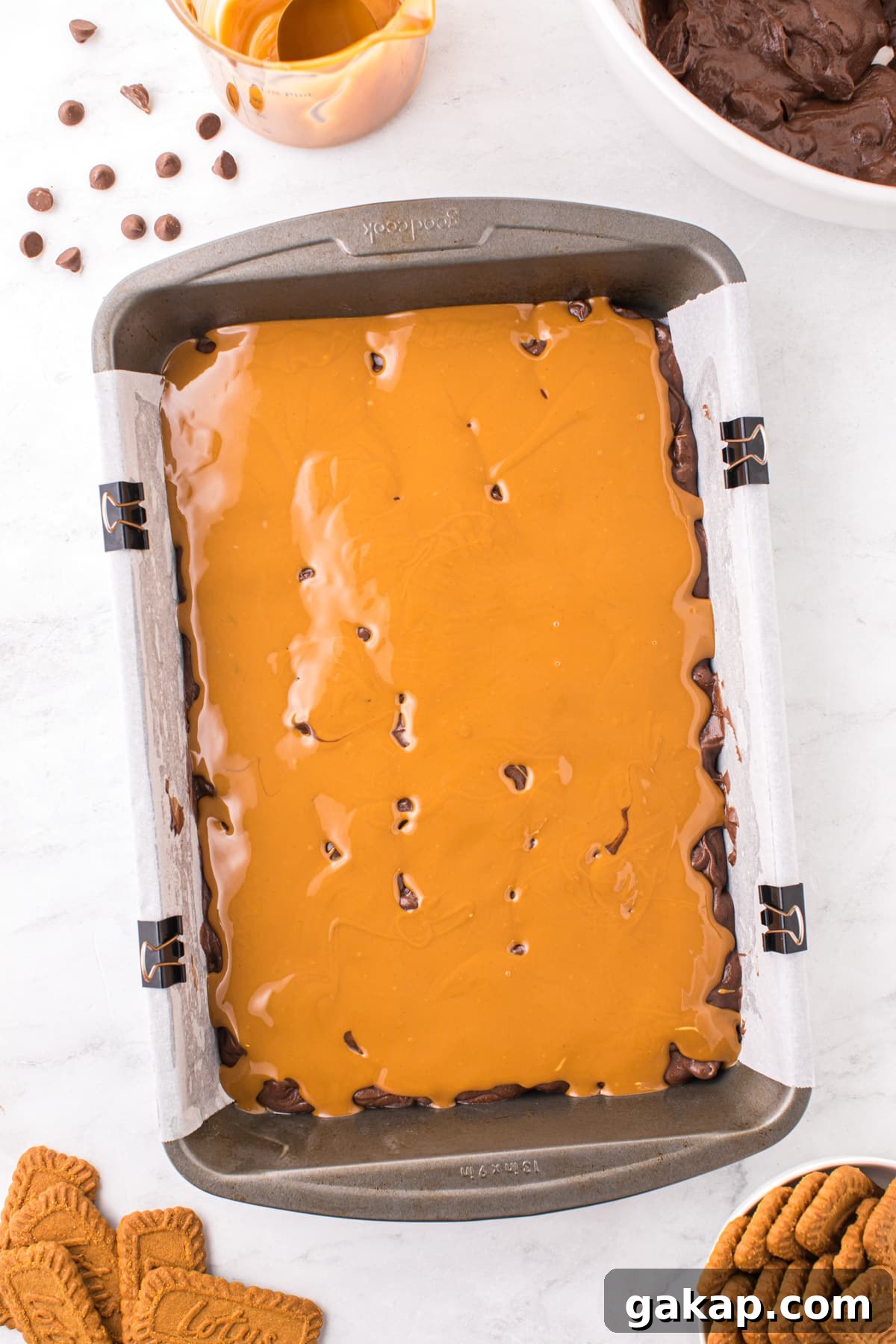 A baking pan filled with brownie batter and topped with cookie butter.