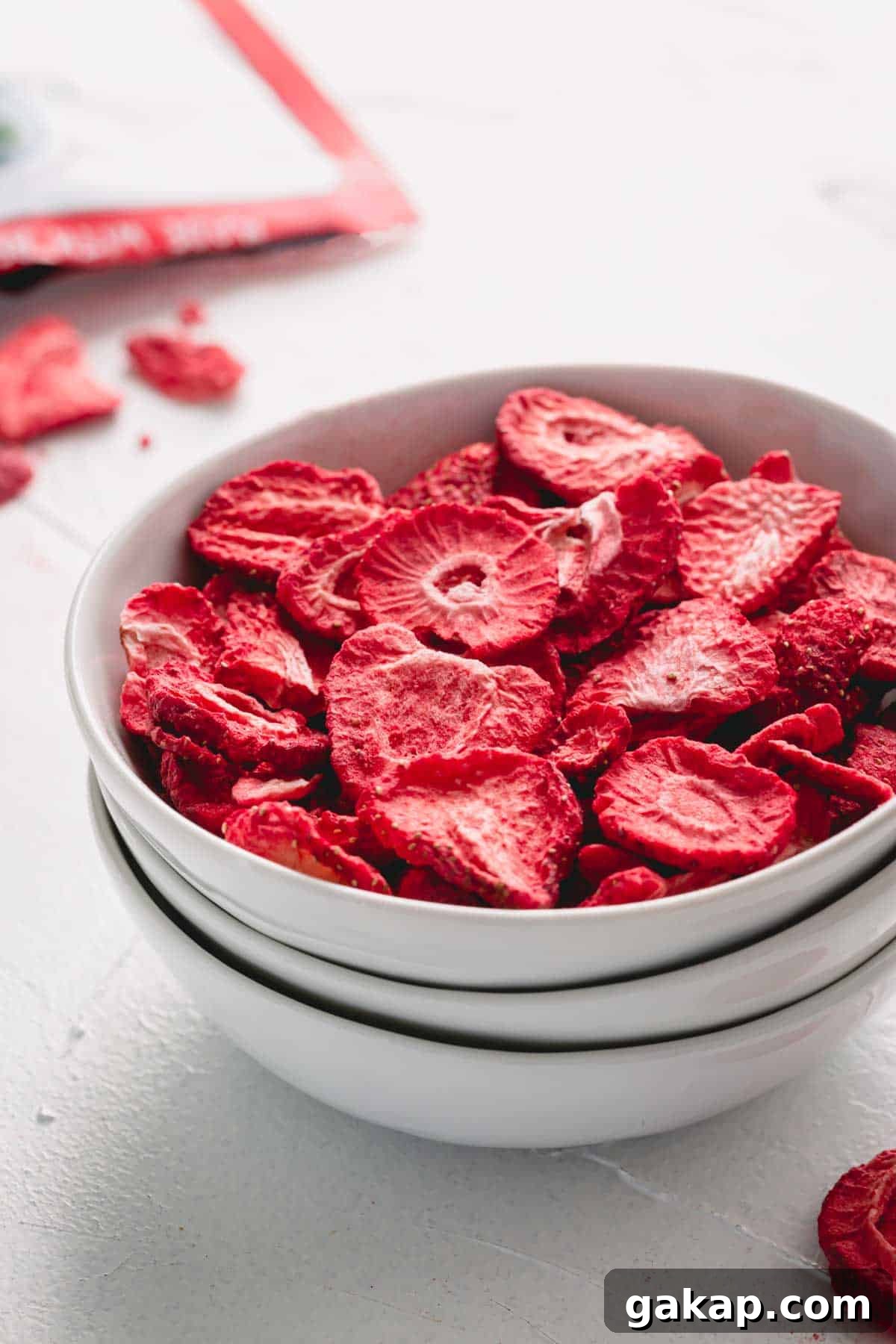 A white bowl of freeze-dried straberries.