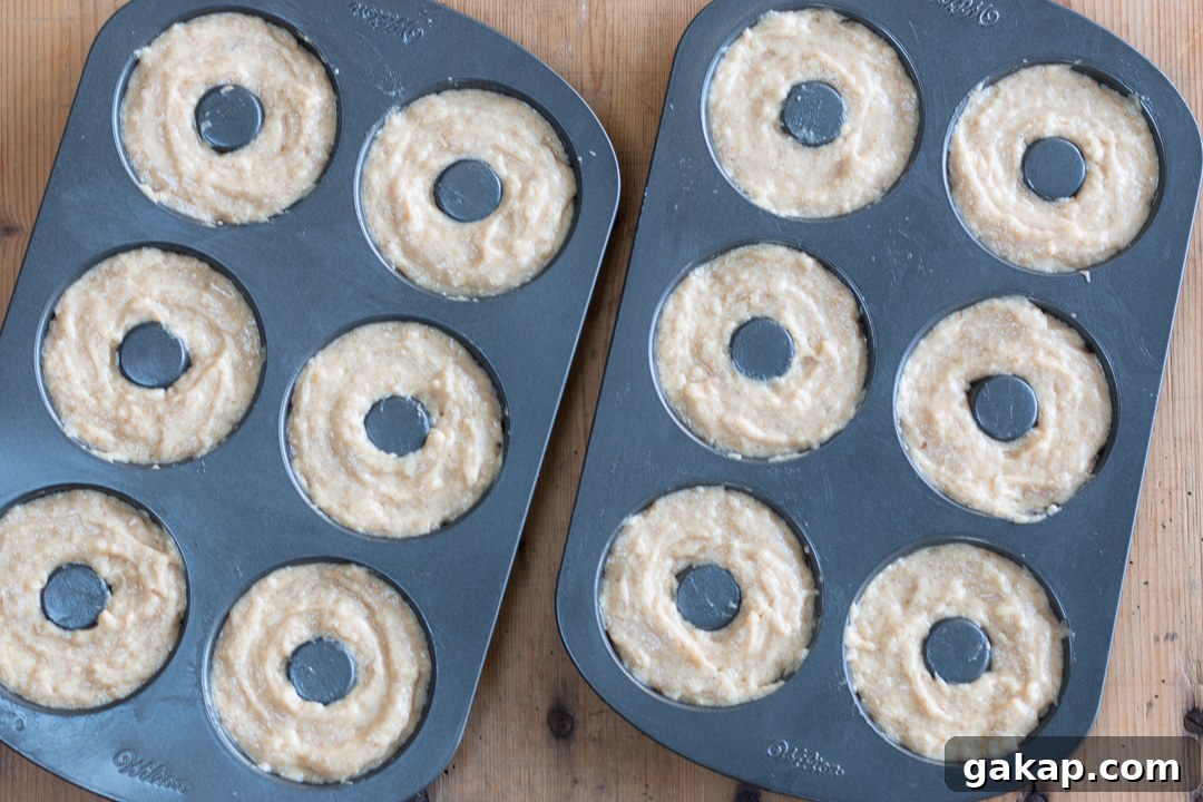 Smooth donut batter into tins