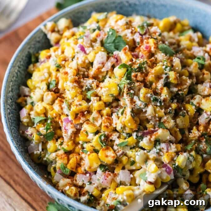 Overhead view of a bowl of Mexican street corn salad in a blue serving bowl.