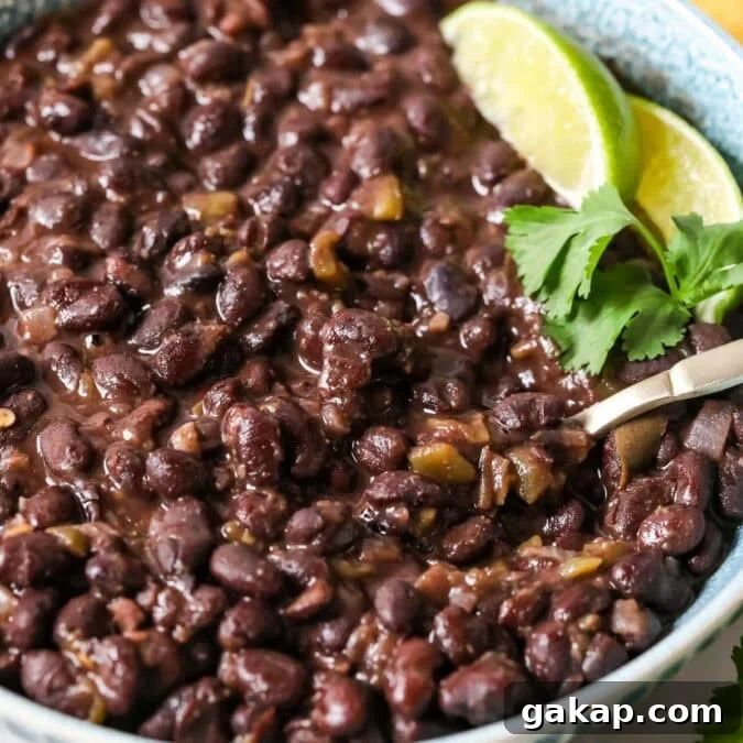 Bowl of cuban-style black beans topped with lime and cilantro.