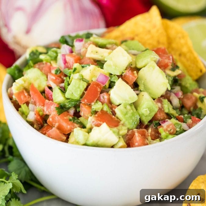 avocado salsa in white bowl with corn chips