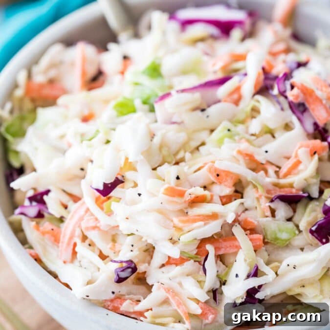 large bowl of homemade coleslaw full of shredded green and purple cabbage, carrots, and creamy dressing co