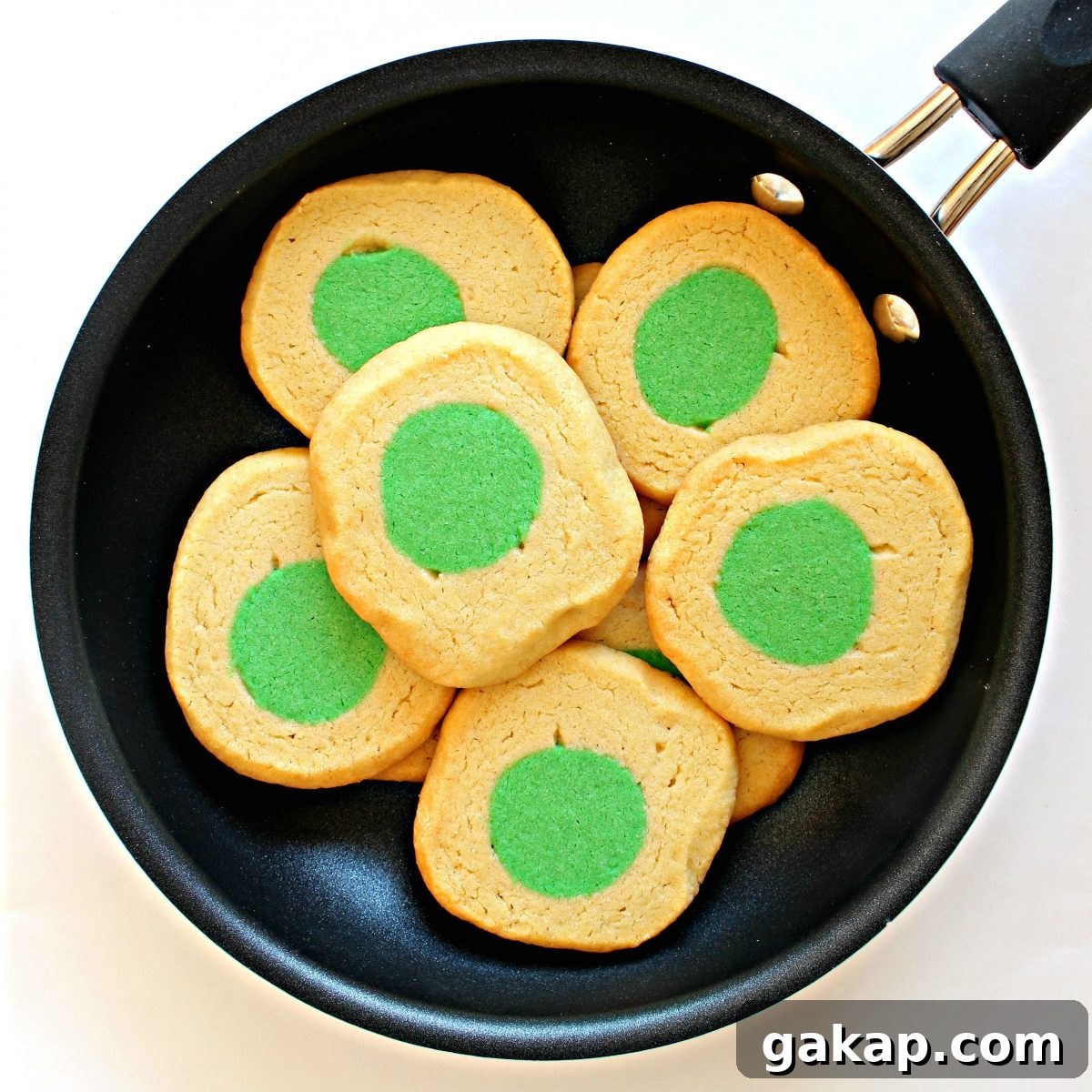 Green Eggs and Ham Sugar Cookies Inspired by Dr. Seuss 3 Cookies that look like eggs with green centers in a frying pan.
