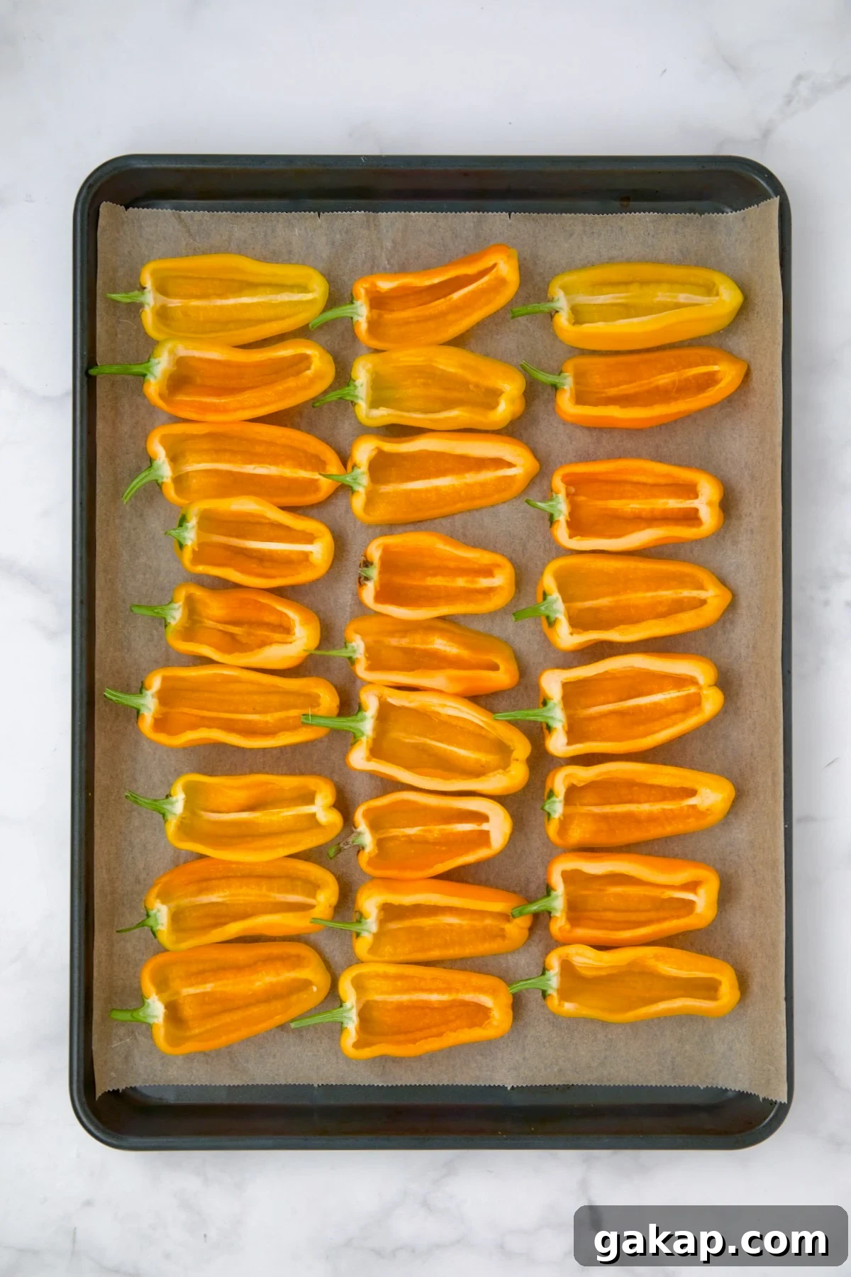 Mini Pepper Tacos: Flavor-Packed Taco-Stuffed Peppers 5 Halved yellow mini peppers on parchment paper lined baking sheet.