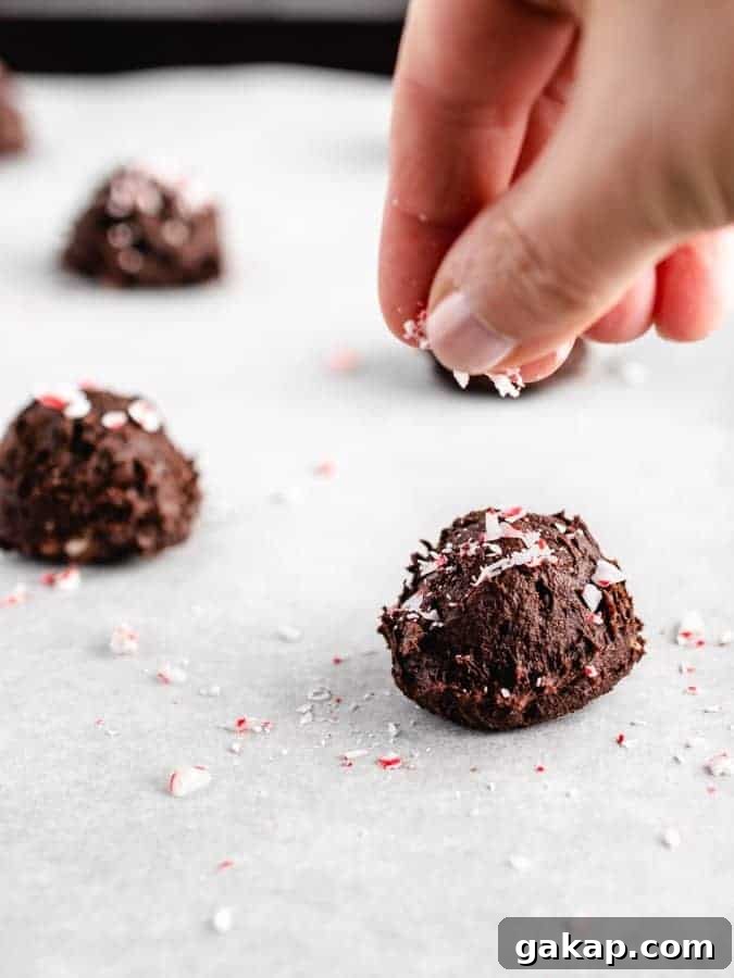 Sprinkling crushed peppermint candy canes on chocolate cookie dough