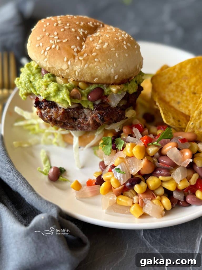 close up of Mexican Hamburger with Cowboy Caviar and tortilla chips on the side.