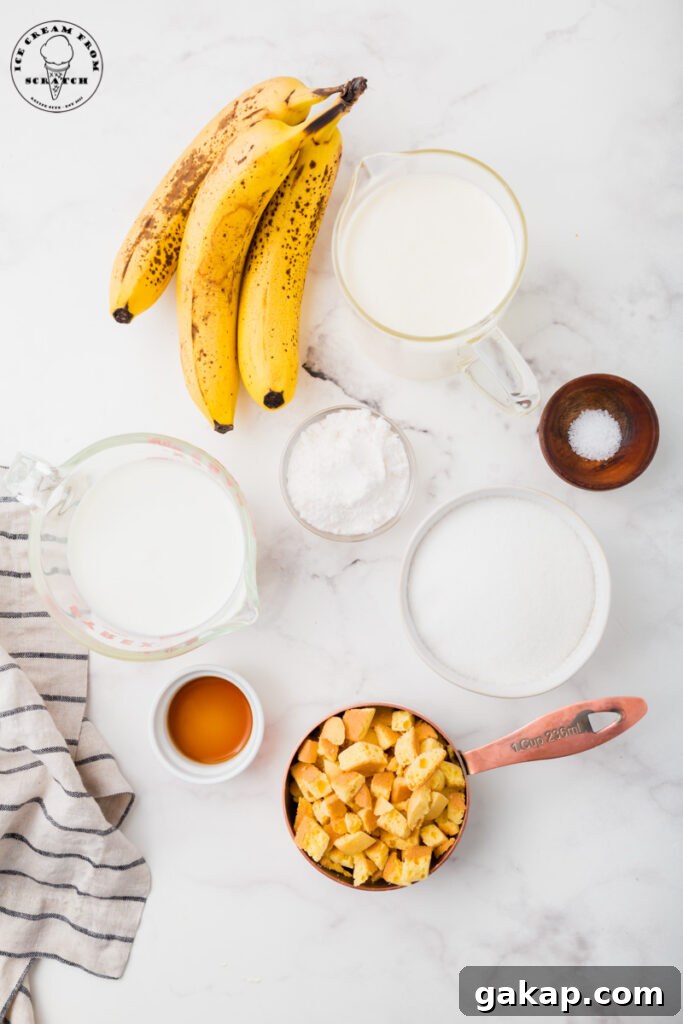 Creamy Banana Pudding Ice Cream Recipe You’ll Love 3 Ingredients needed for banana pudding ice cream on a marble countertop, all in separate bowls. Includes ripe bananas, chopped cookies, sugar, and cream.