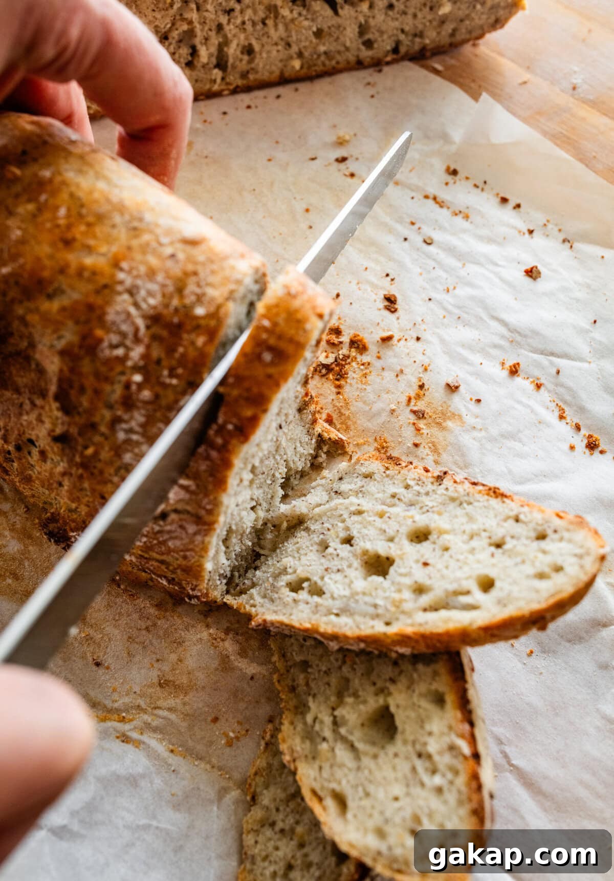 Slicing a loaf of crusty Italian bread on a cutting board. 