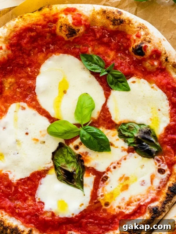 Two pizzas with mozzarella and basil on a wooden table. Neapolitan pizza margherita recipe.