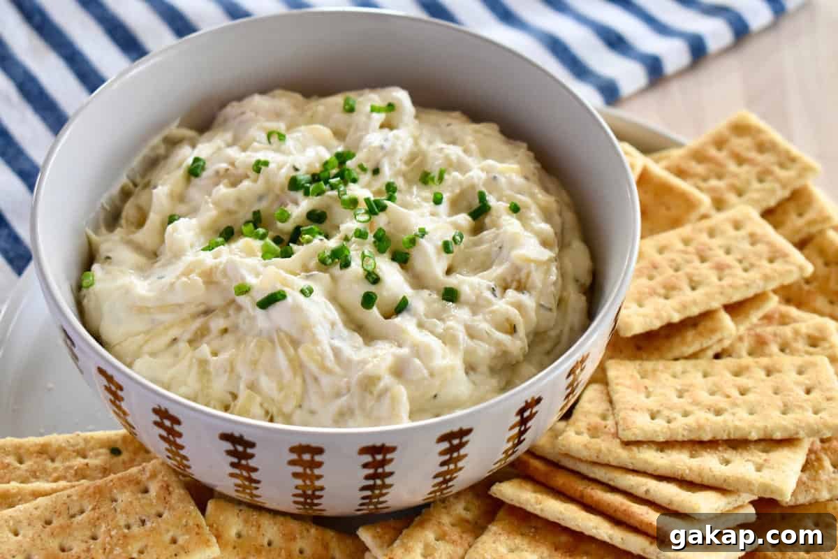Caramelized Onion Dip with Greek Yogurt in a bowl with crackers next to it. 