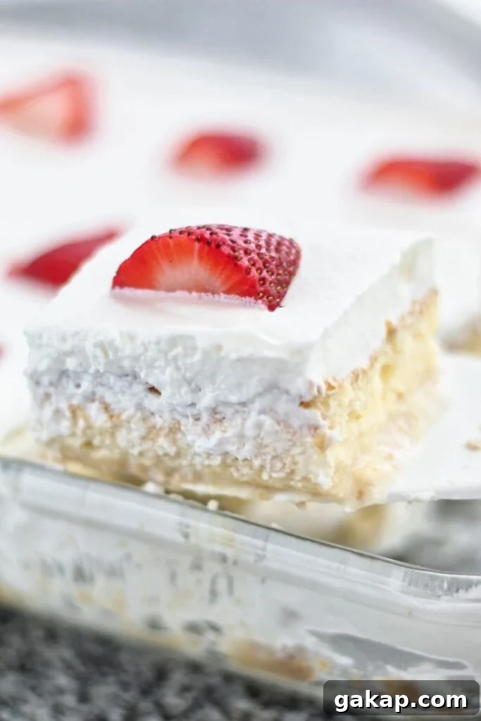 scooping slice of tres leches cake out of glass pan