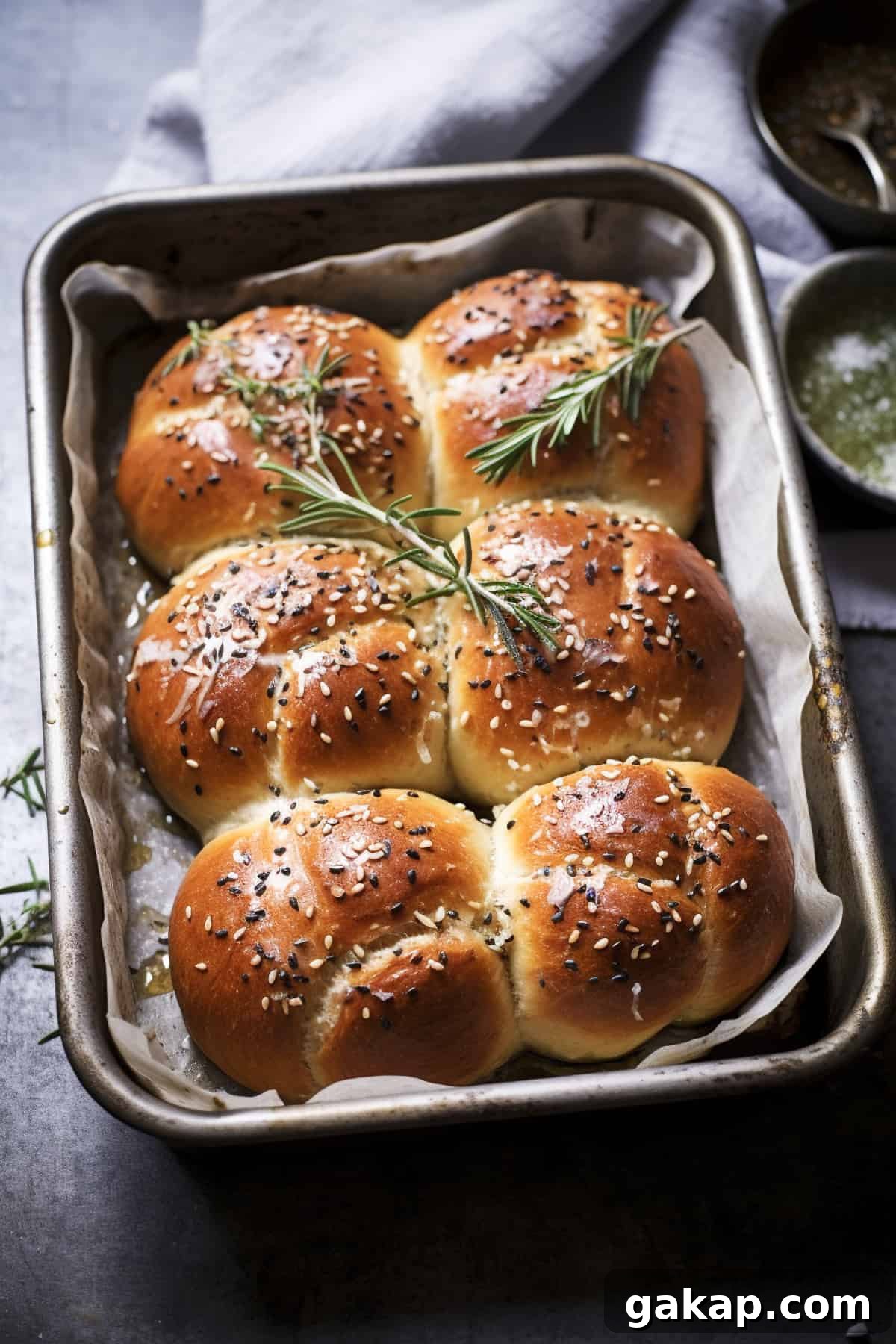 Bread rolls with seeds and herbs in a tray.
