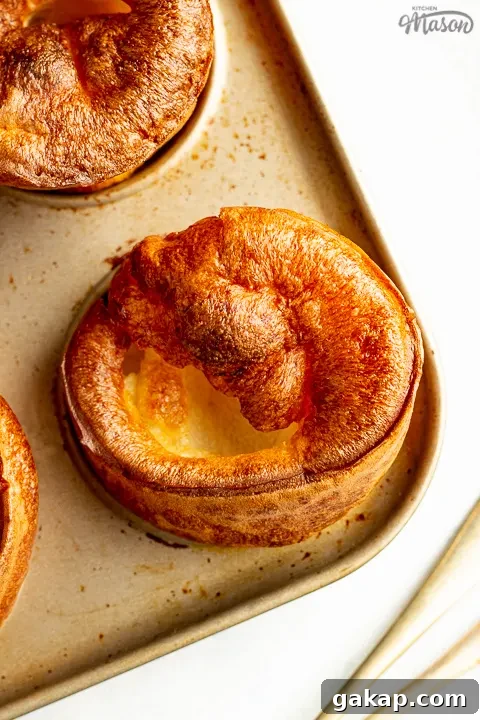 Yorkshire puddings in a pan with a fork