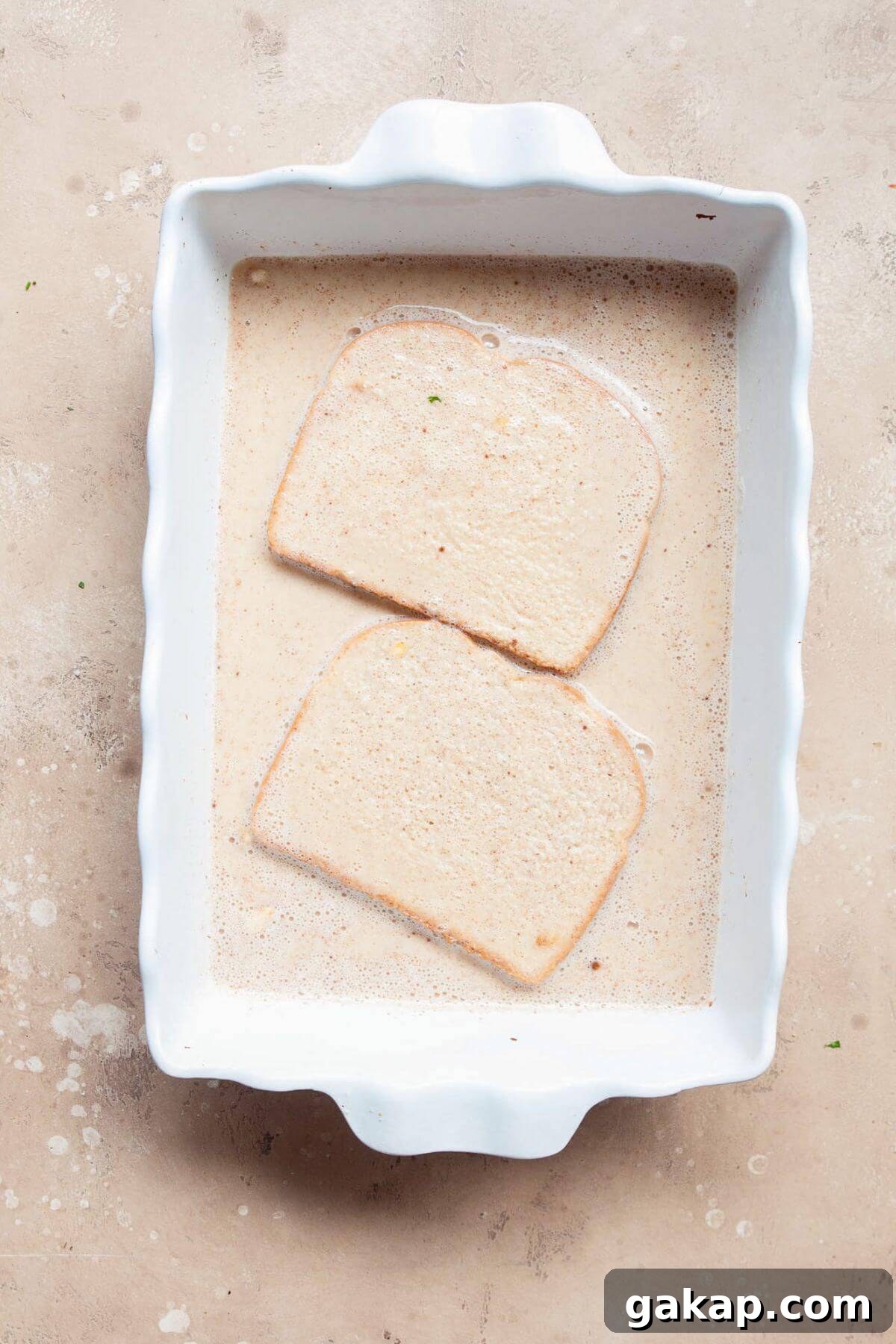 Soaking bread in french toast milk wash made from egg whites, protein powder, and milk.