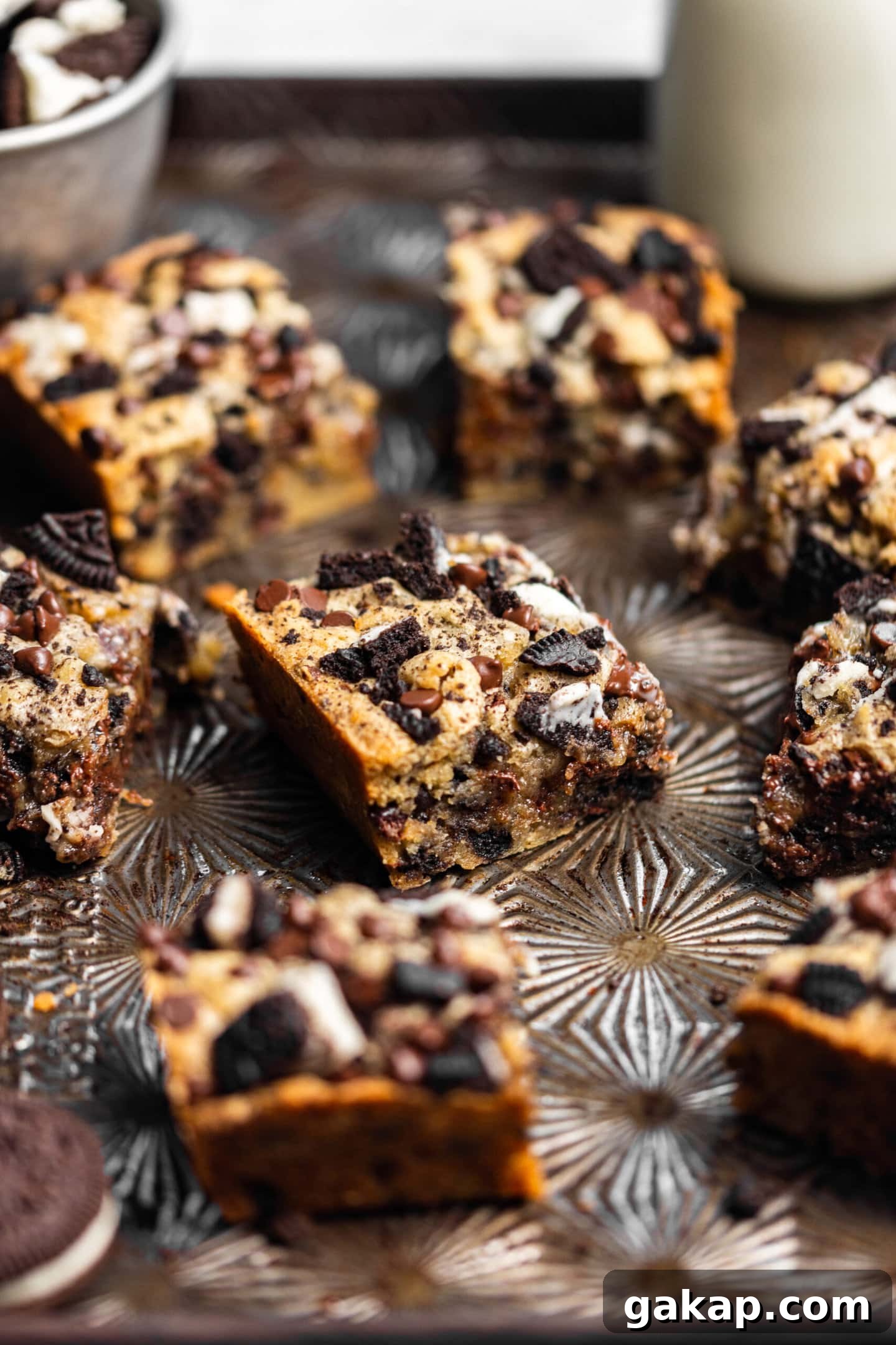 Small batch Oreo blondies on a baking sheet next to a glass of milk.