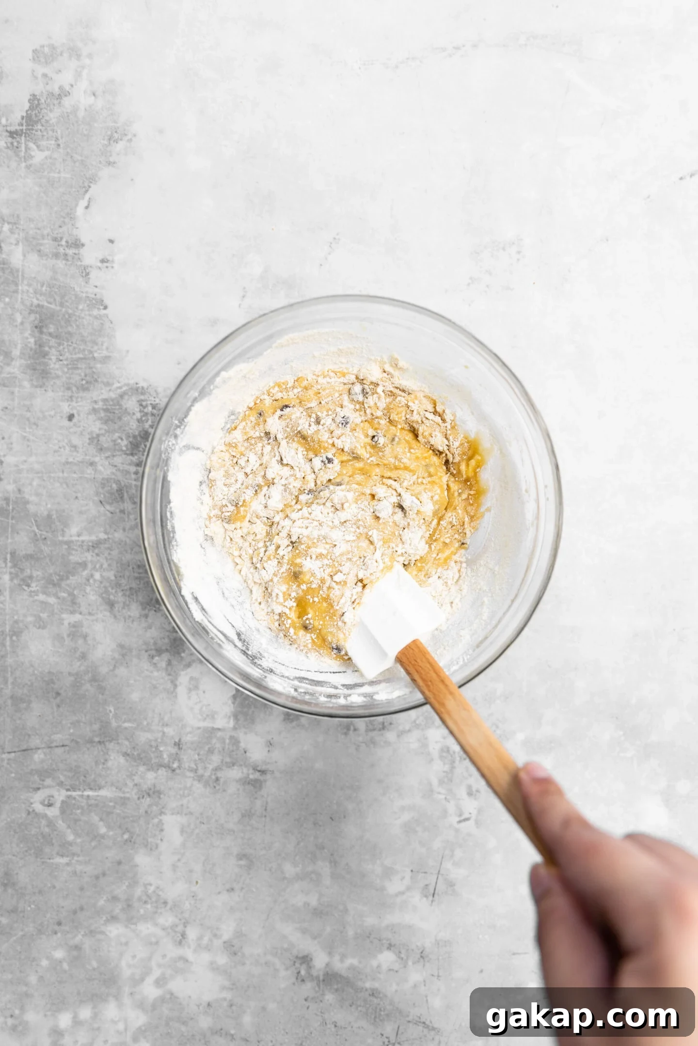 Dry ingredients and chocolate chips being stirred into blondie batter