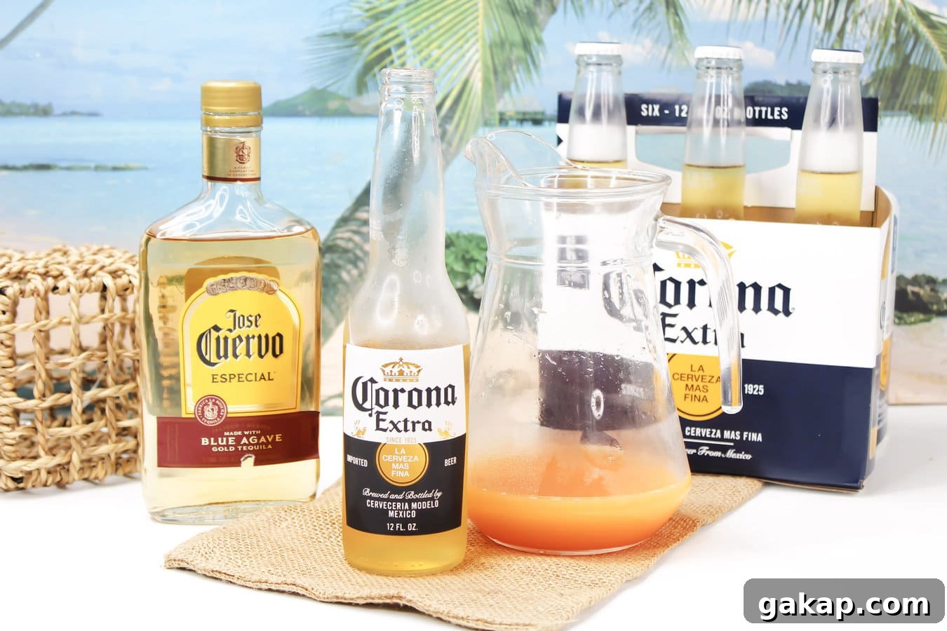 Corona beer beside a large pitcher of Corona Sunrise cocktail
