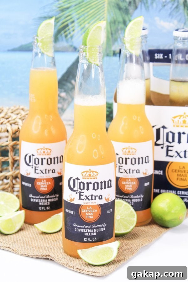 Three Corona cocktails in beer bottles garnished with lime