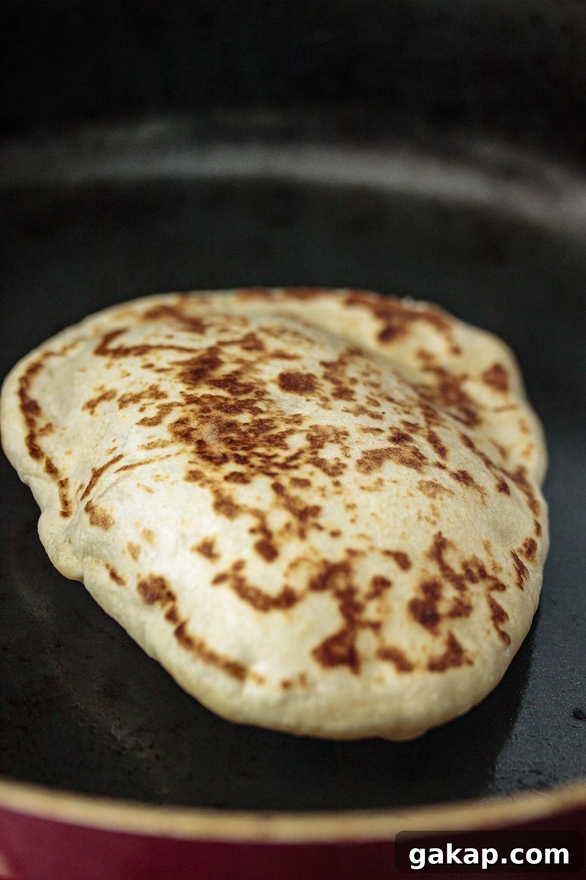 Puffing sourdough naan, while cooking.