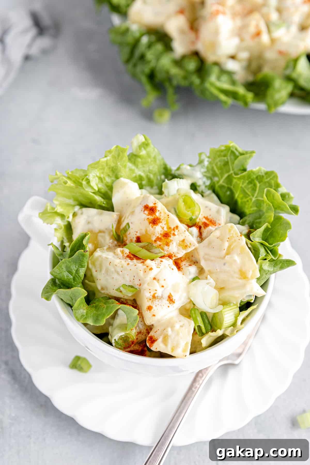 A Close-Up Shot of a Potato Salad in a Large Cup with Lettuce Leaves