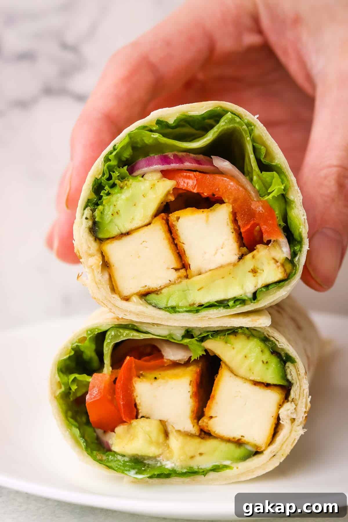 Holding a tofu wrap.