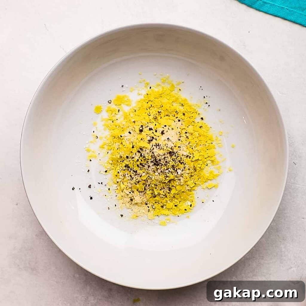 Mixing nutritional yeast with the seasonings.